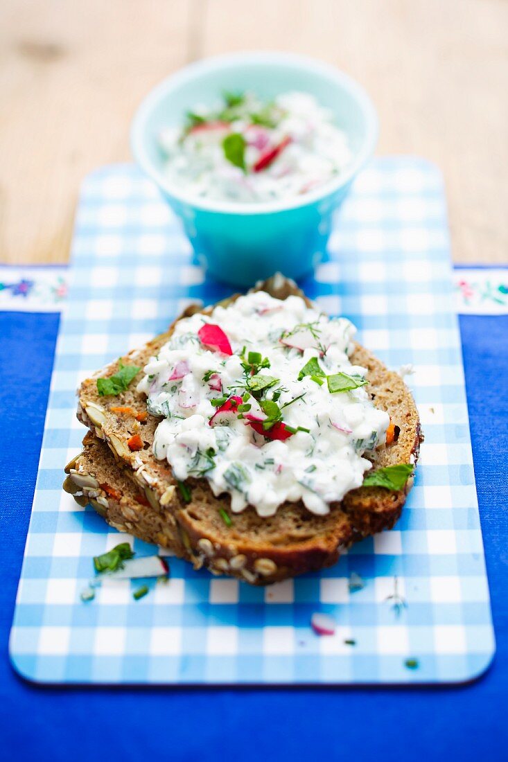 A slice of wholemeal bread topped with cottage cheese on a breakfast tray