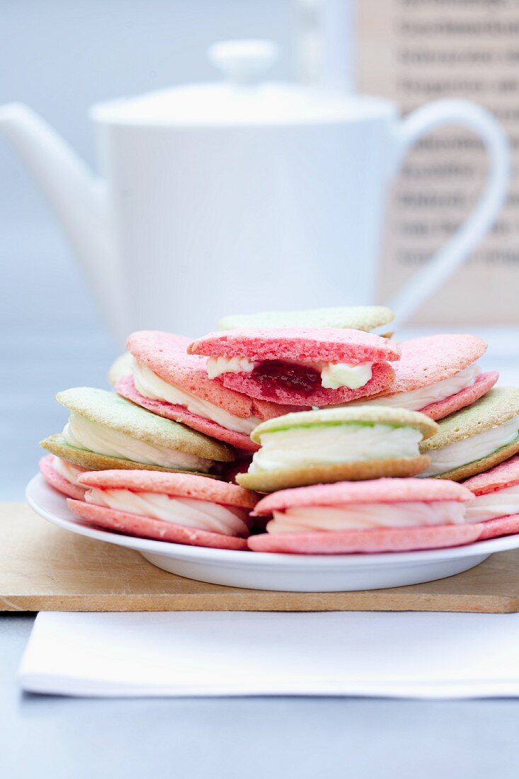 Various macaroons with a teapot in the background