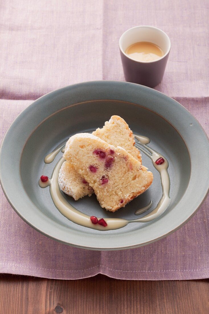 Two pieces of advocaat cake with pomegranate seeds in a light blue dish