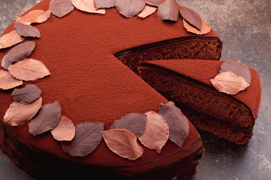 Chocolate torte, sliced, decorated with chocolate leaves
