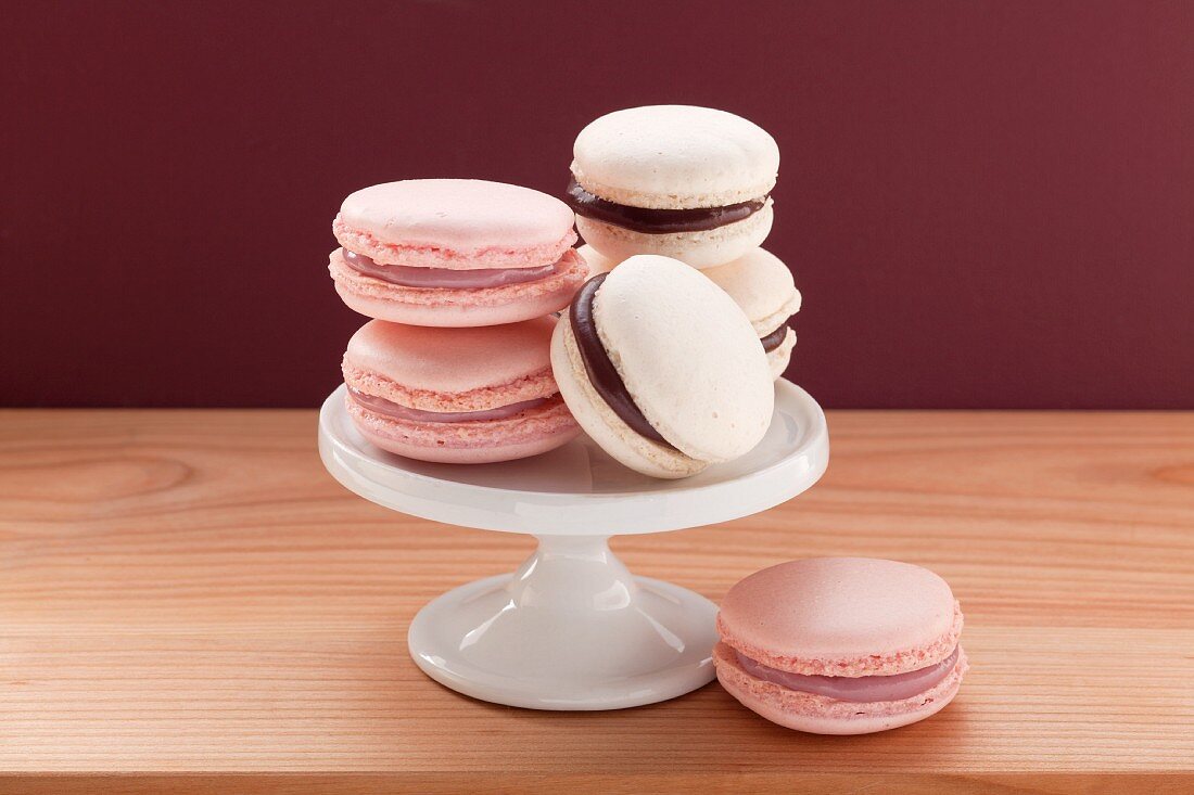 Kleiner Tortenständer mit rosa Macarons und weißen Macarons mit Schokoladenfüllung