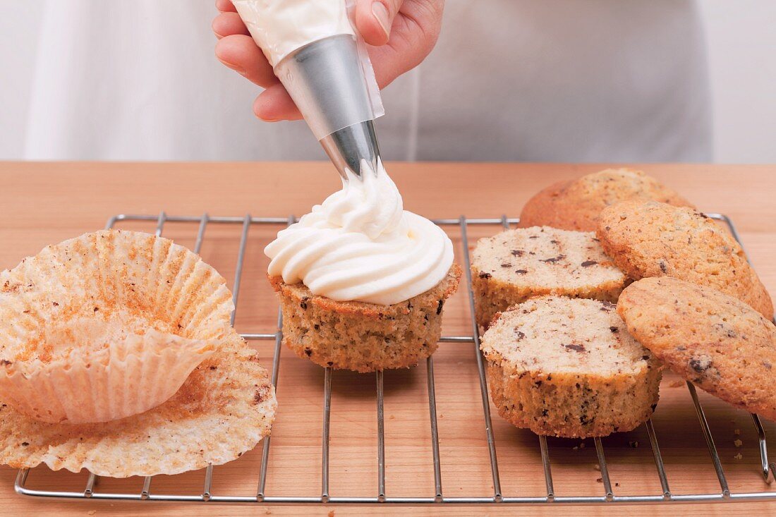 Muffins auf Kuchengitter mit Sahnecreme füllen