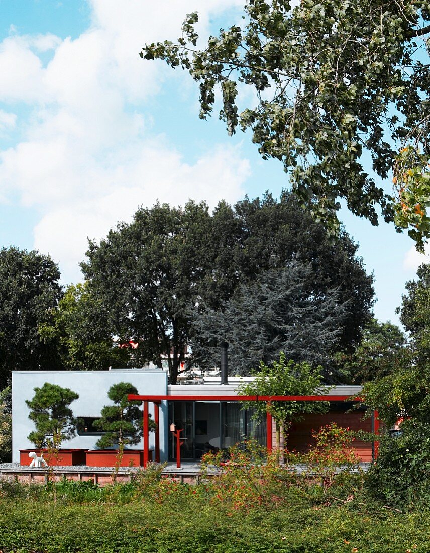 Moderner Bungalow mit bepflanzter Terrasse und Farbgestaltung der einzelnen Bauteile