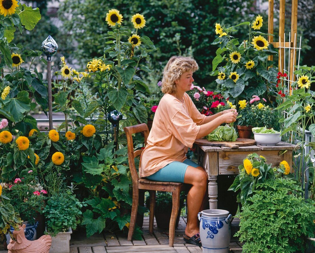 Woman with lettuce on summery terrace