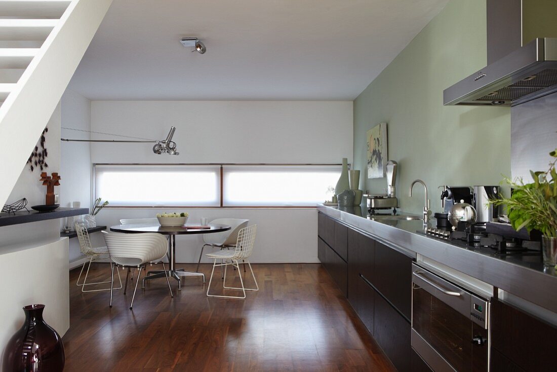 Handle-free kitchen with dark brown, oak fronts and dining area