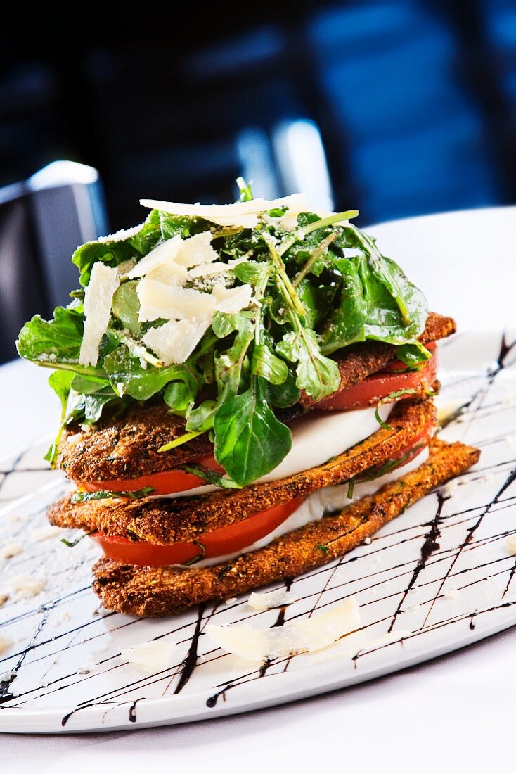 Schichtsalat mit gebratenen Auberginen, Tomaten, Mozzarella, Rucola und Parmesan