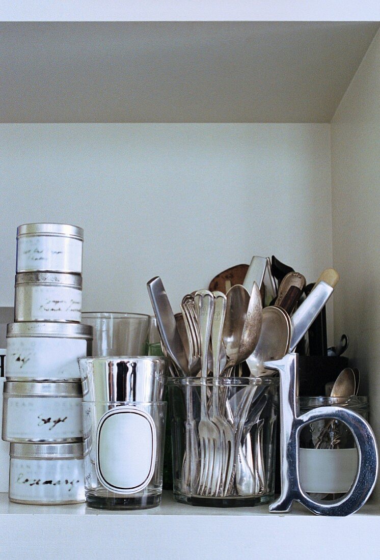 Close up of shelf with silver cutlery and containers