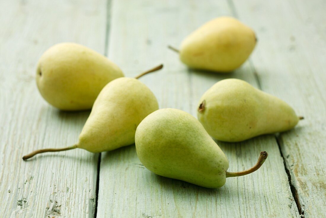 Five pears on a wooden surface