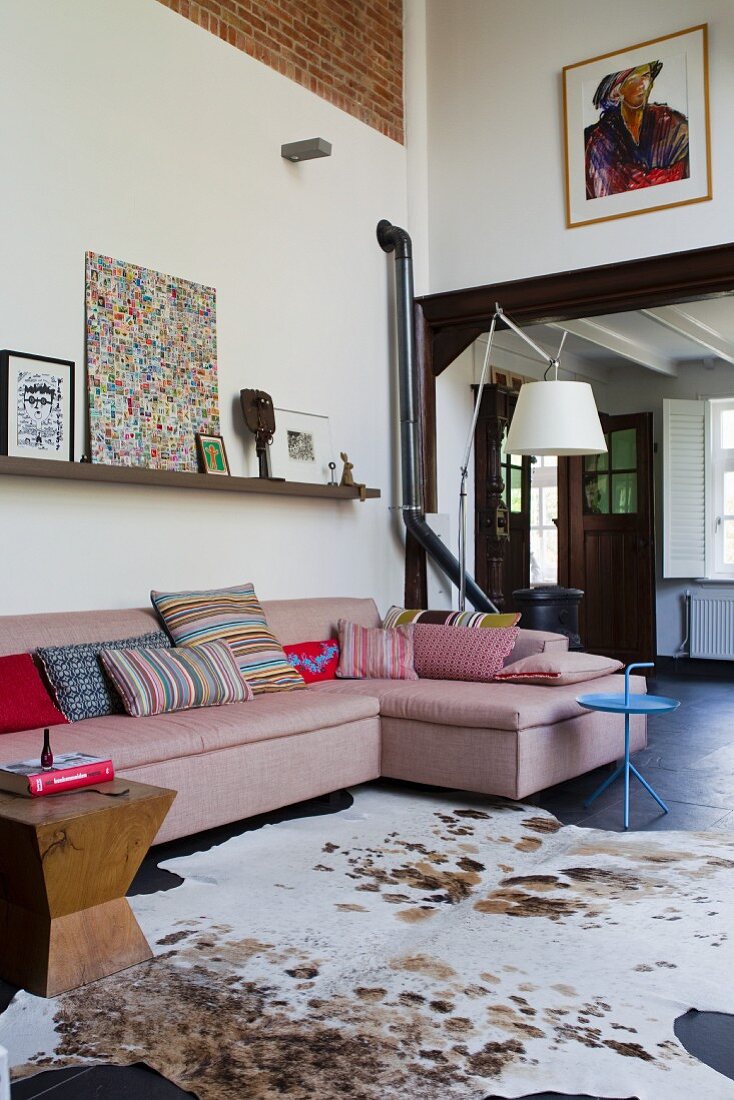 Animal-skin rug and sofa in open-plan interior of renovated country house