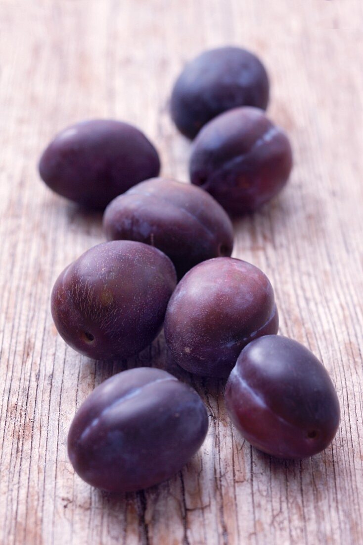 Plums on a wooden surface