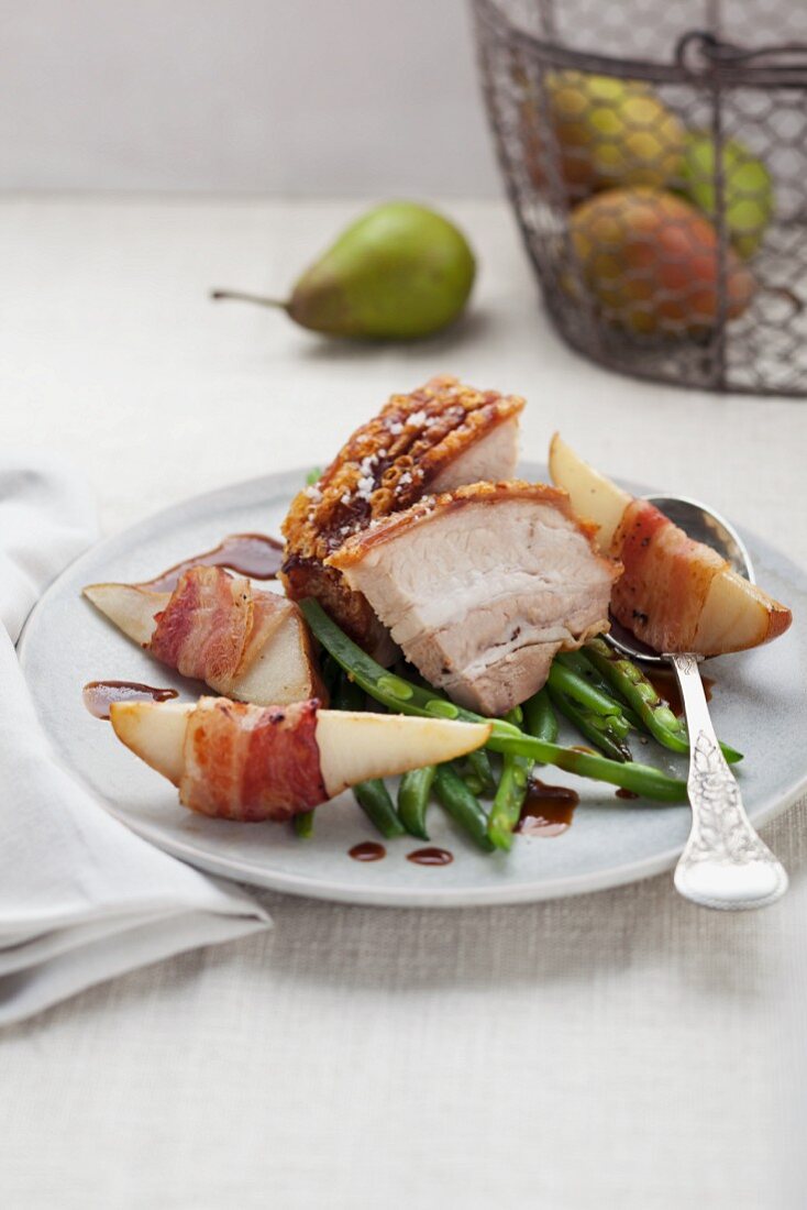 Crackling roast of pork with pears, beans and bacon