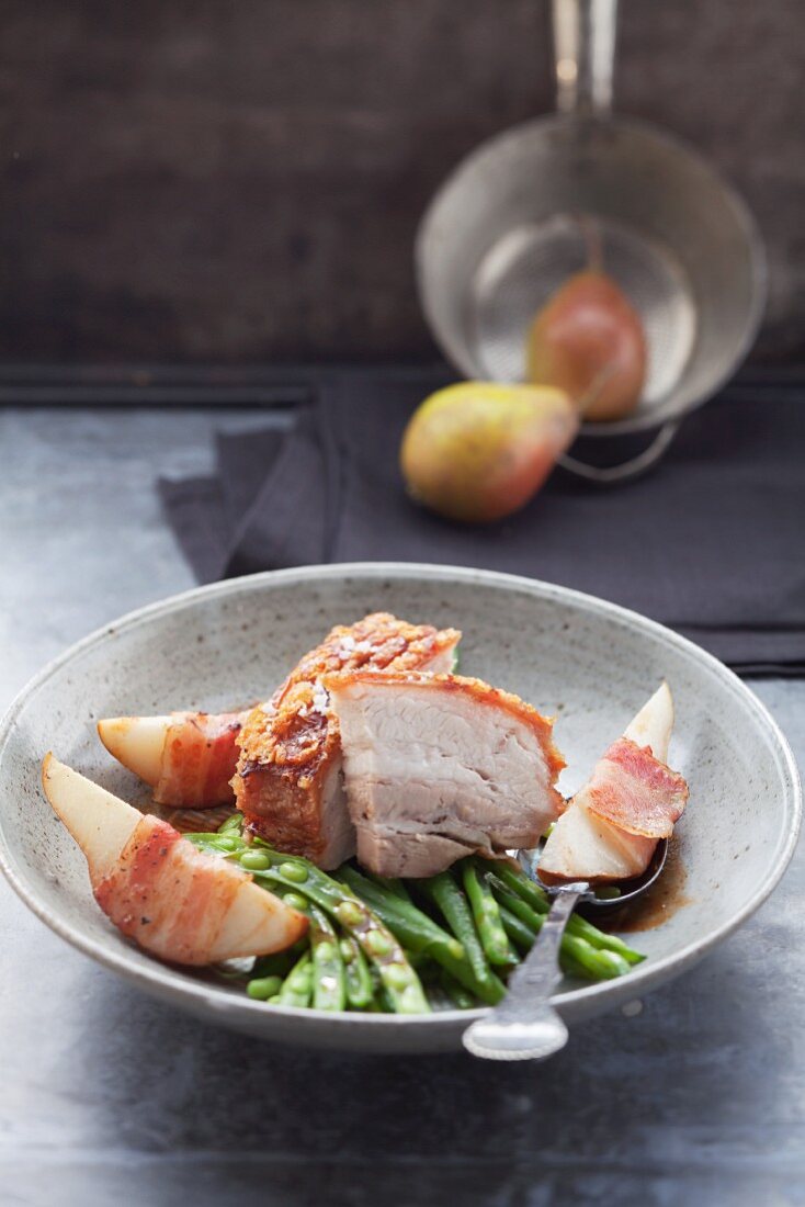 Crackling roast of pork with pears, beans and bacon