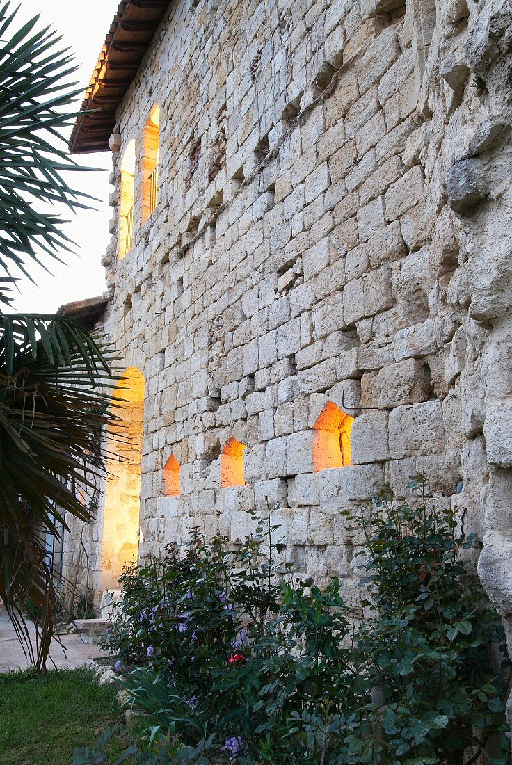 Beleuchtete Fensteröffnungen in der Fassade des Château Maignaut
