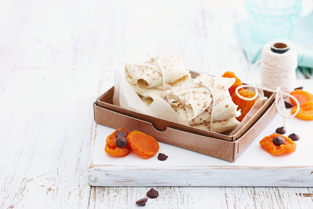 Crepe packages in a box with dried apricots and chocolate chips
