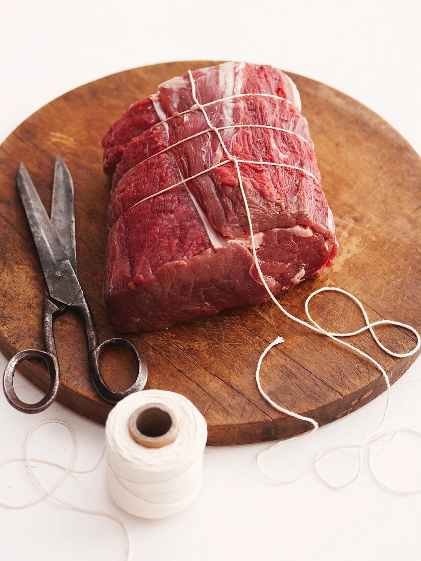 Raw roast beef tied with kitchen twine