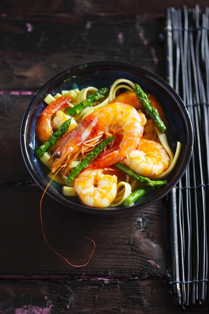 Prawn stew with green asparagus and noodles, seen from above