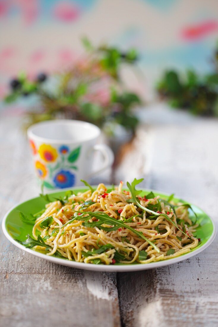 Homemade pasta with rocket on a green plate