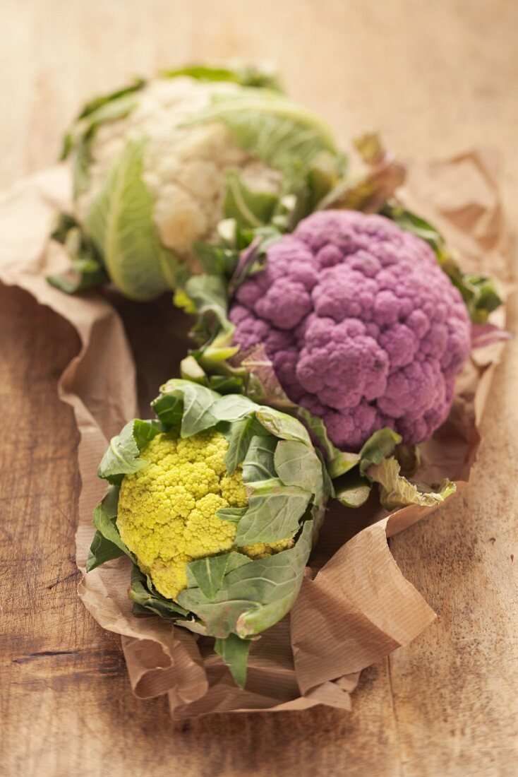 A trio of cauliflowers: white, purple and green