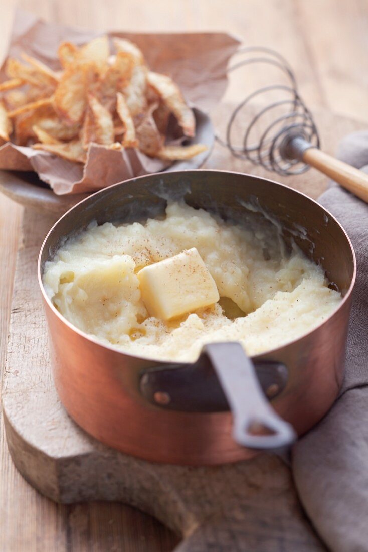 Mashed potatoes in a saucepan on a wooden board