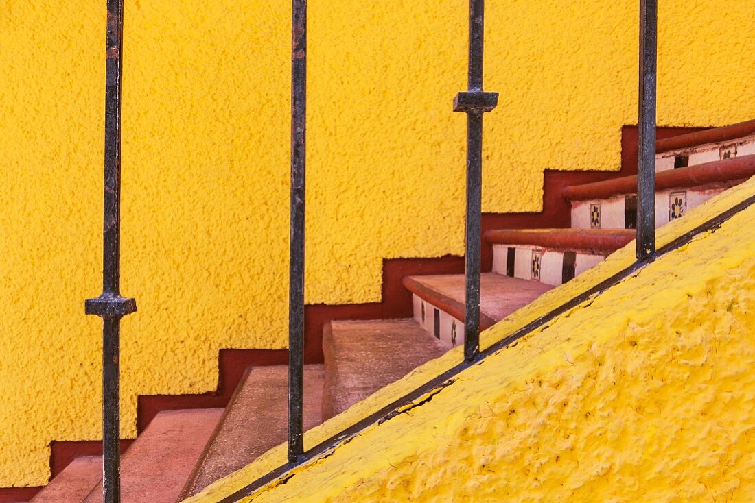 Staircase with sunshine yellow walls, red treads and tiled risers