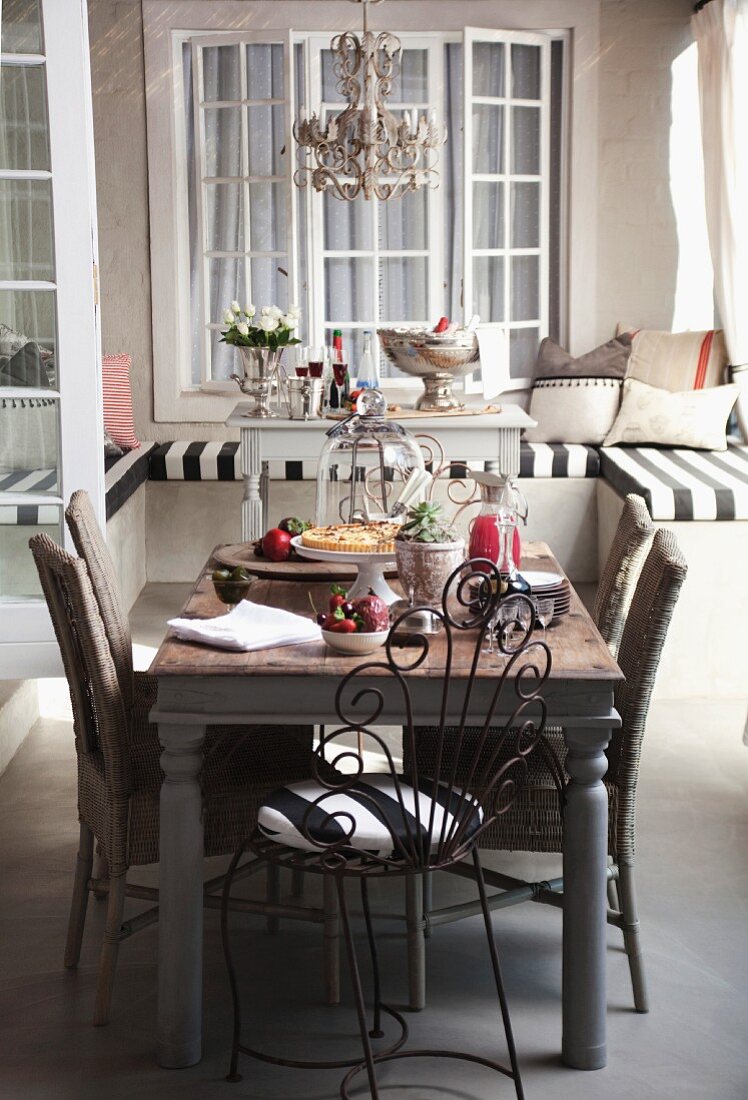 Cake for afternoon tea on rustic kitchen table in front of niche with window seat