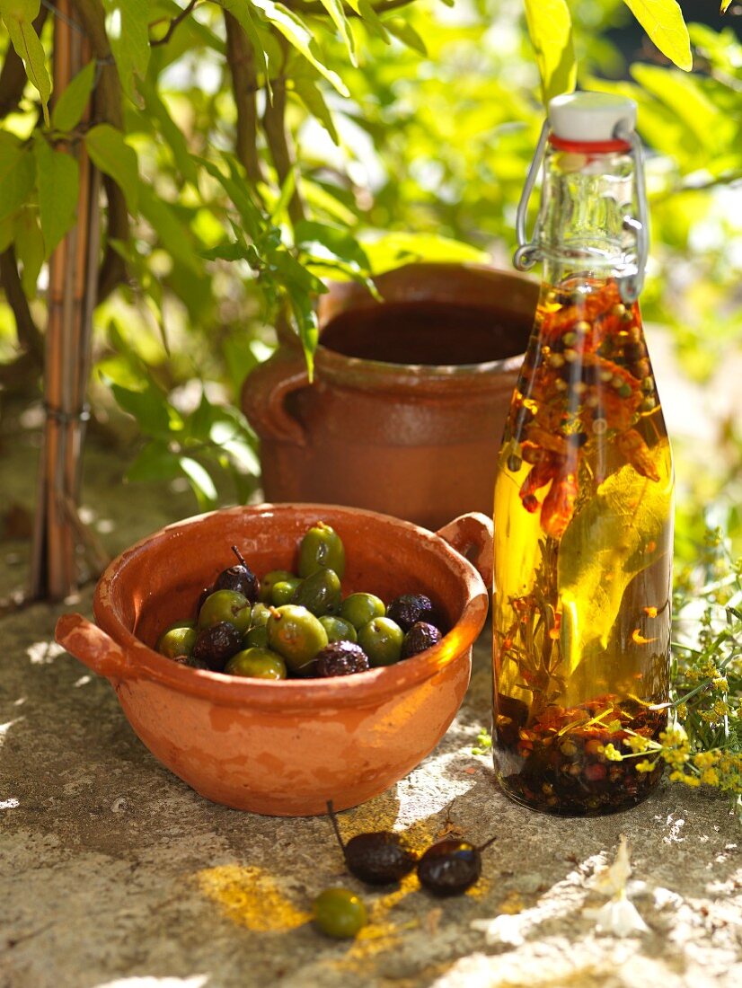 Marinierte Oliven und eine Flasche Olivenöl