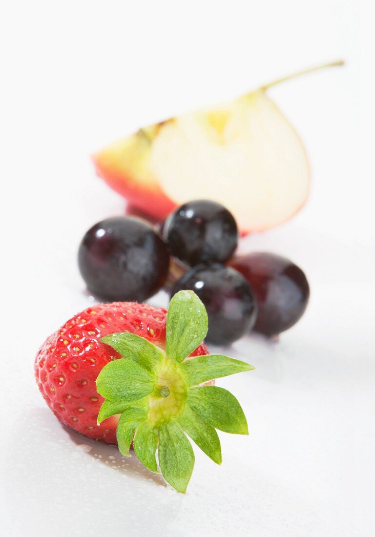 Strawberries, red grapes and an apple wedge