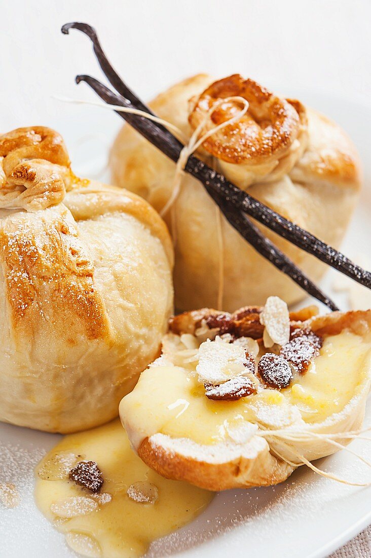 Apple wrapped in pastry with vanilla sauce, raisins and almonds