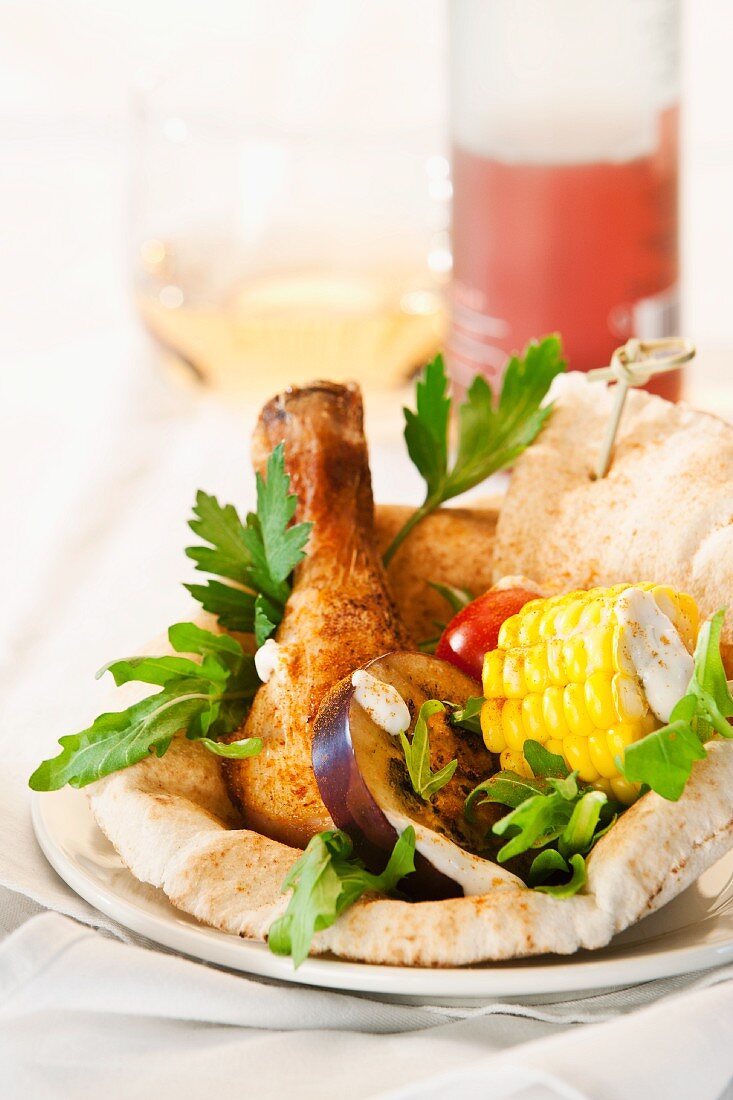 Grilled vegetables and a grilled chicken leg on unleavened bread