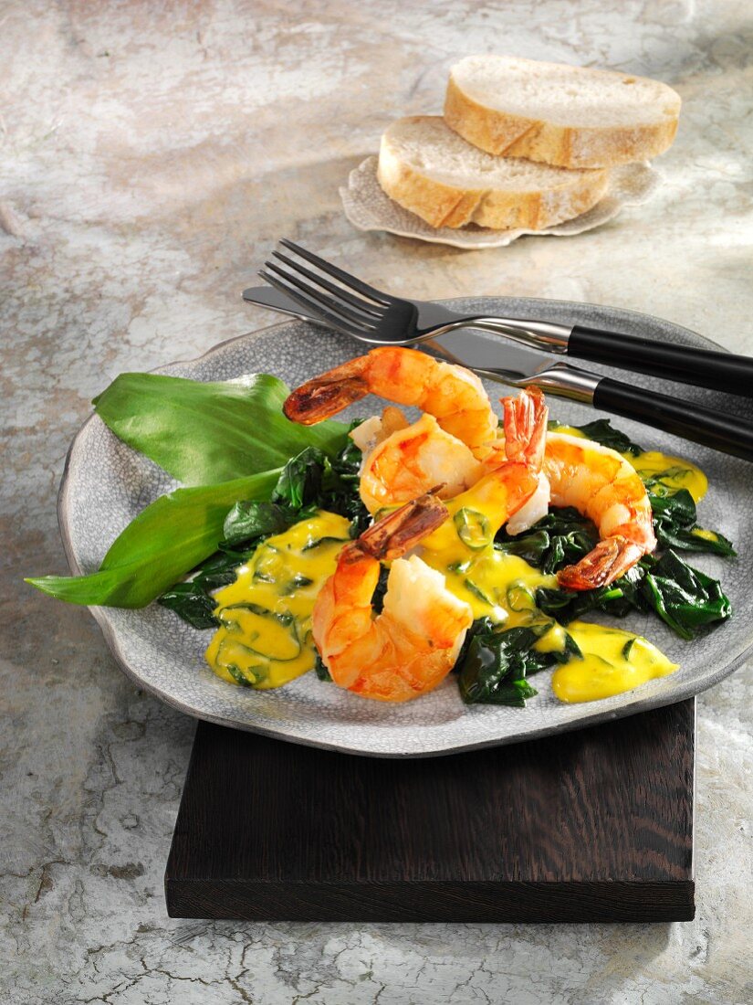 Fried prawns on a bed spinach with saffron and ramson sauce