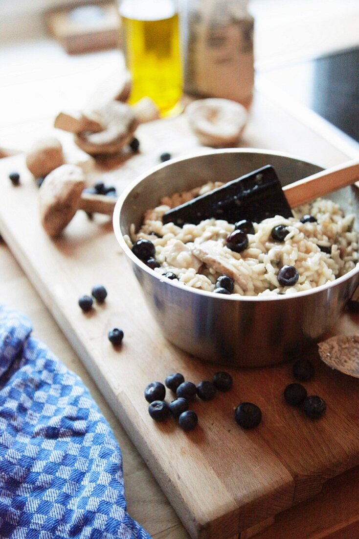 Porcini mushrooms risotto with blueberries being prepared