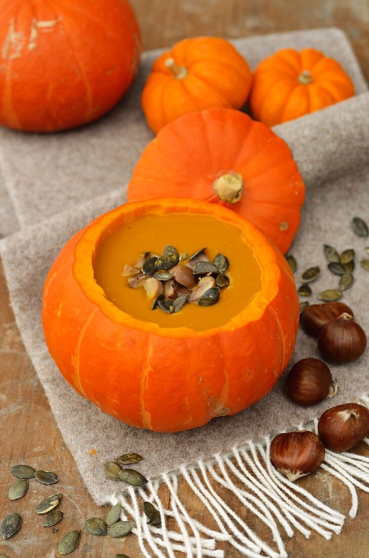 Pumpkin soup with chestnuts and pumpkin seed in a hollowed-out pumpkin