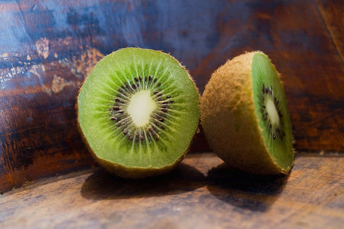 A halved kiwi on a wooden surface