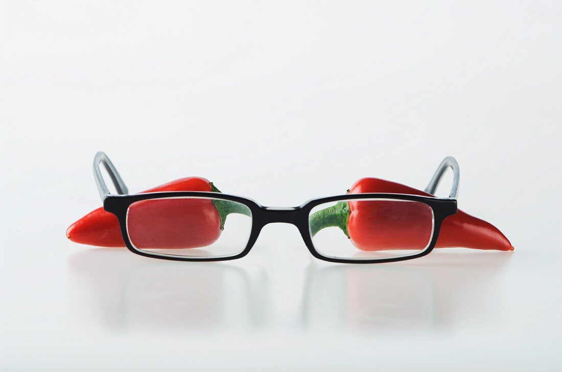 Two red chilli peppers with a pair of glasses