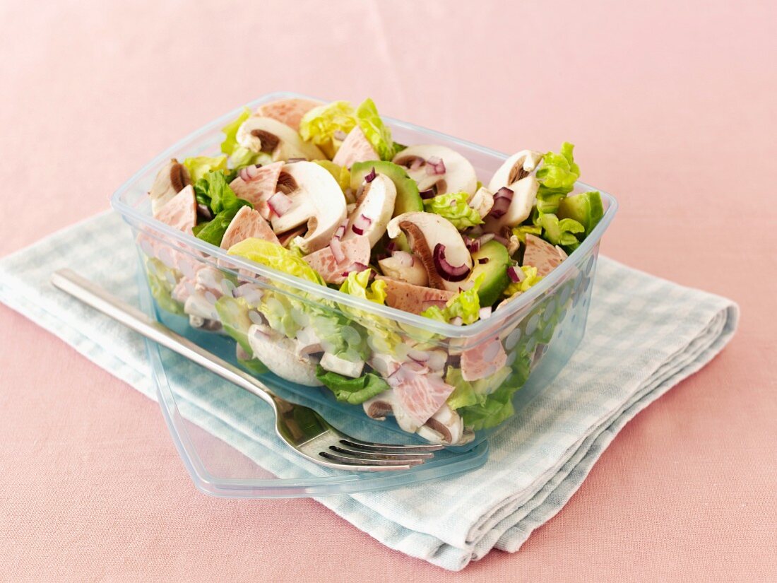 Mushrooms salad with avocado and sausage in a lunchbox