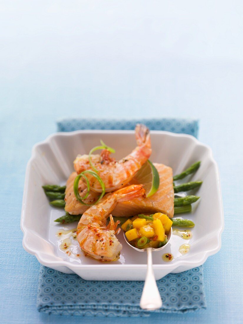 Fried salmon with prawns on a bed of asparagus with mango salsa