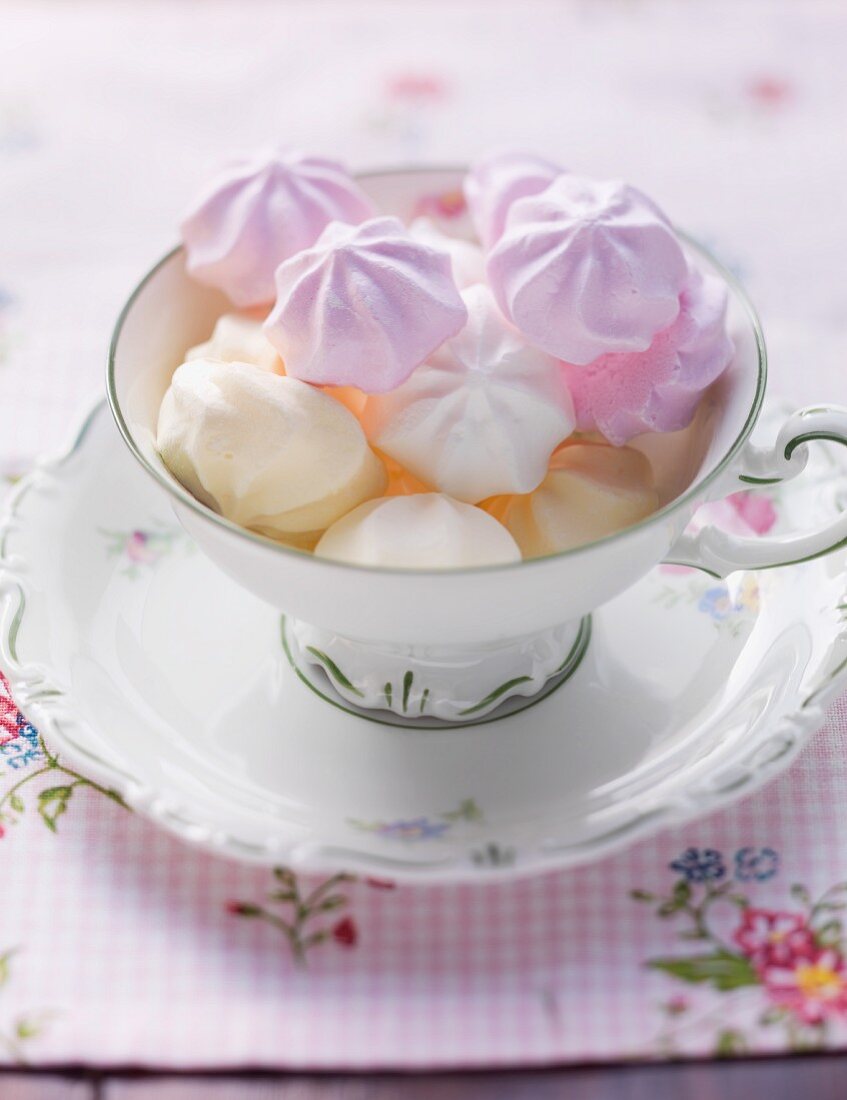 Various different coloured meringues in a cup