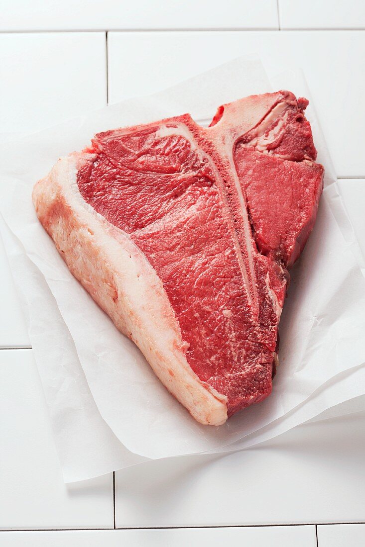 A T-bone steak on parchment paper