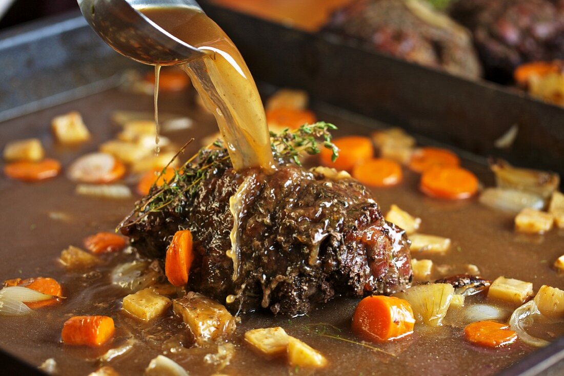 Roast venison with root vegetables in a pan