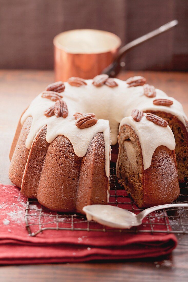 A banana wreath cake with icing and pecan nuts