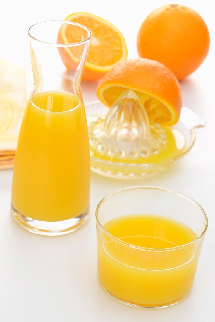 Frisch gepresster Orangensaft in einer Glaskaraffe und im Glas