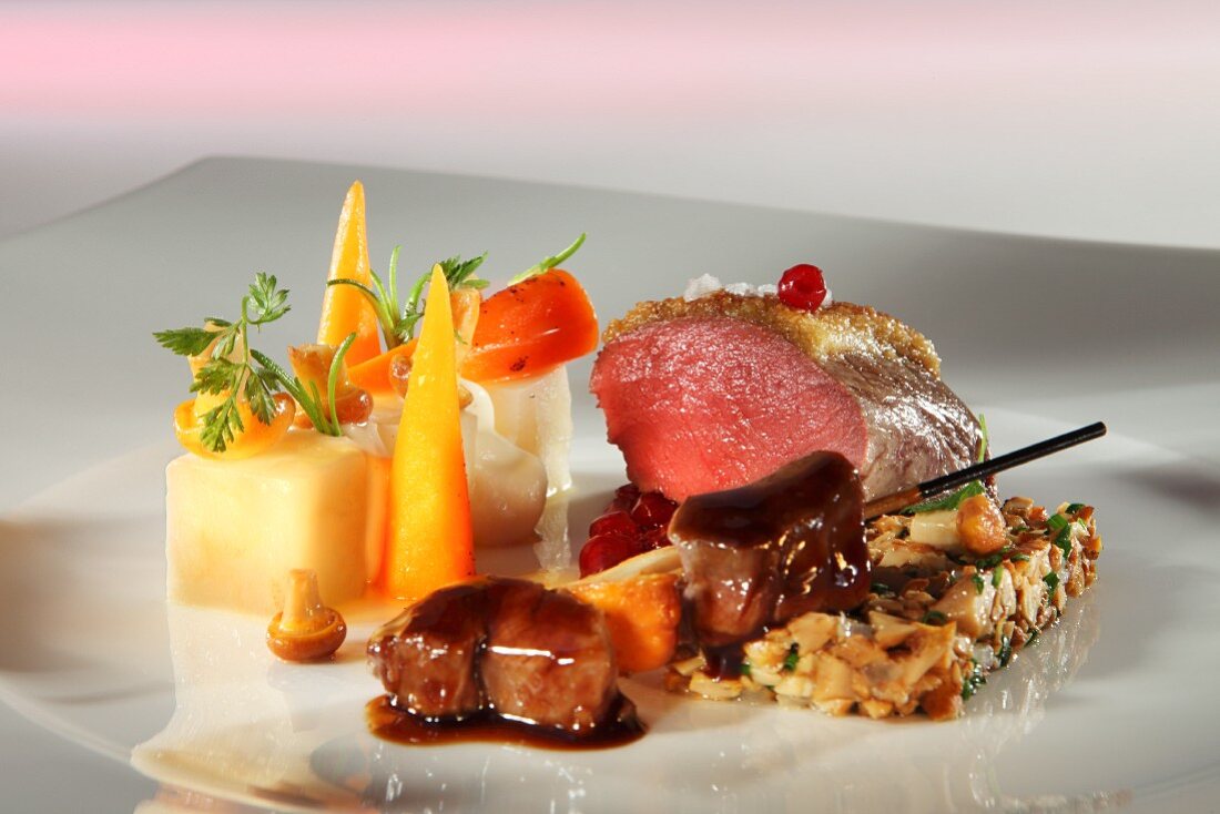 Saddle of venison on a bed of chanterelles with a side of vegetables