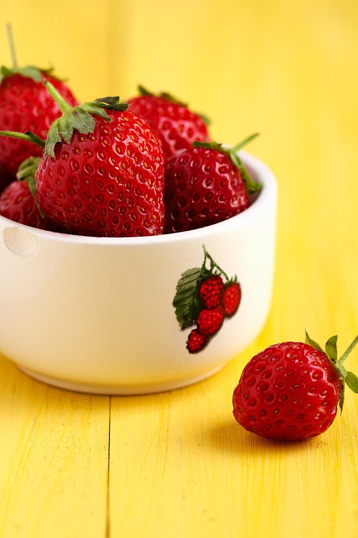 Strawberries in a bowl with a raspberry picture