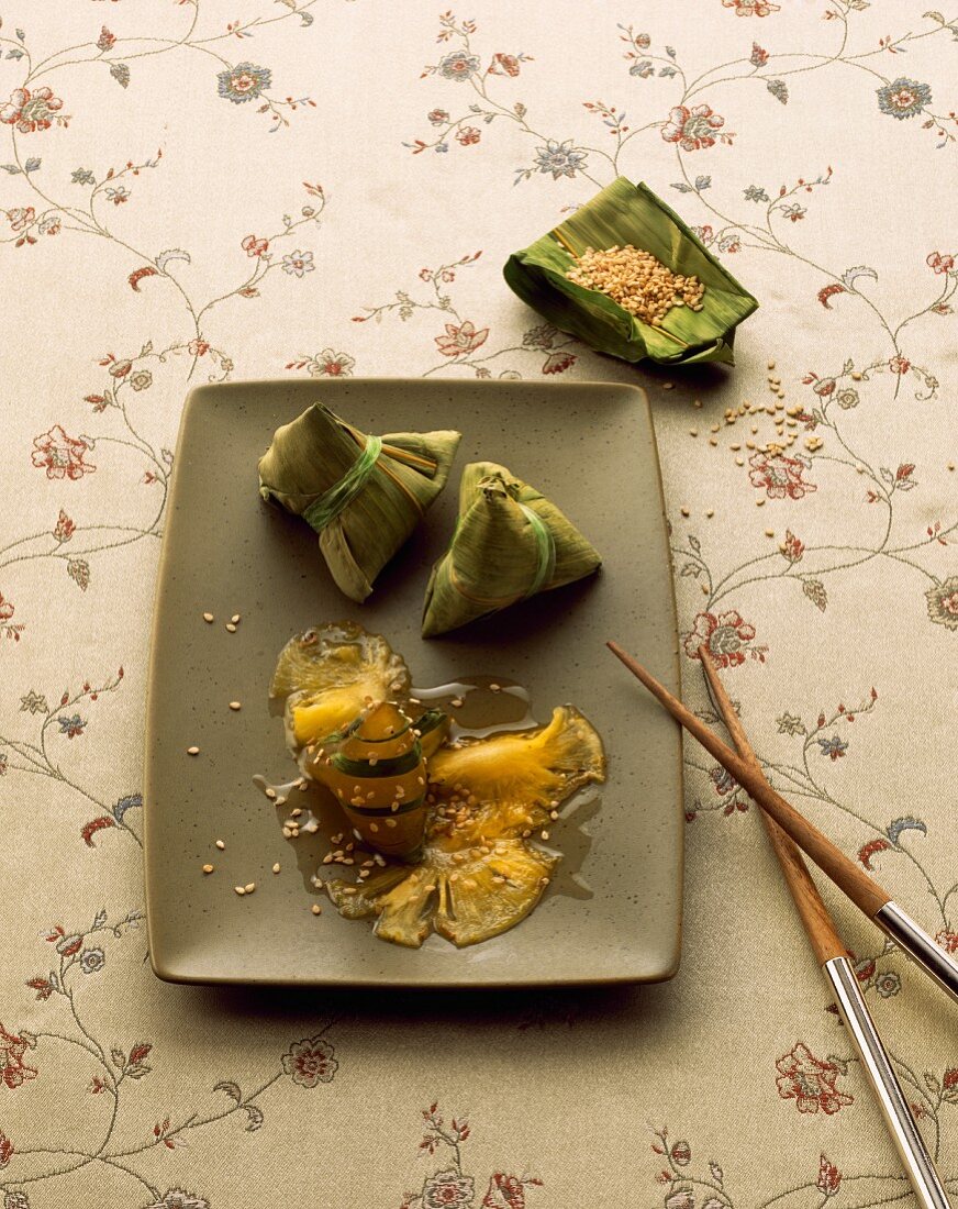 Pineapple wrapped in banana leaves with sesame seeds (Asia)