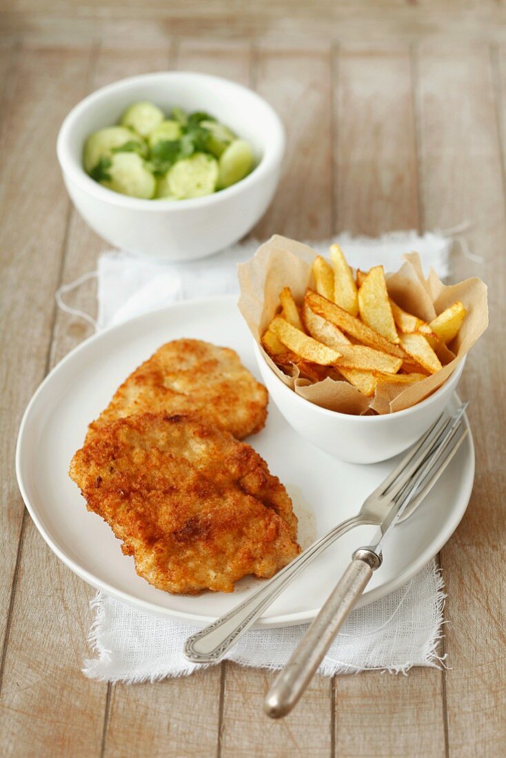 Putenschnitzel mit Pommes frites und Gurkensalat