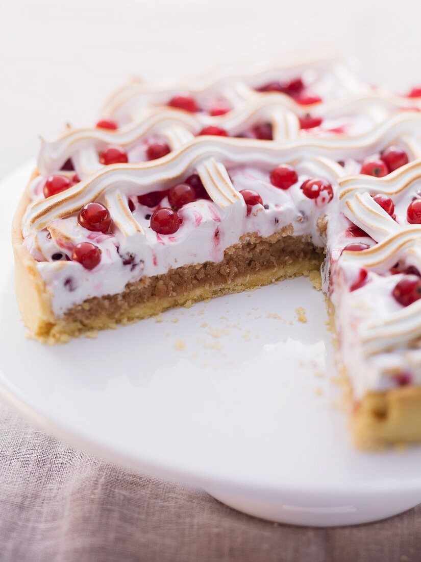 A meringue cake with redcurrants, sliced