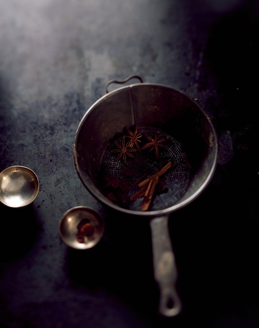 Star anise and cinnamon sticks in an old saucepan