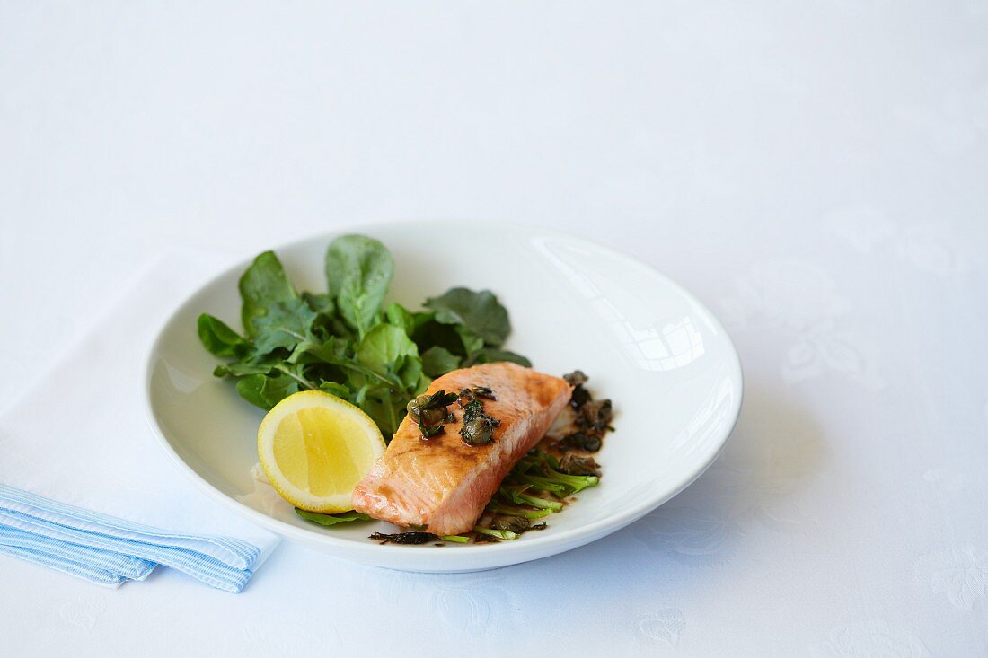 Fried salmon fillet with capers and a side salad