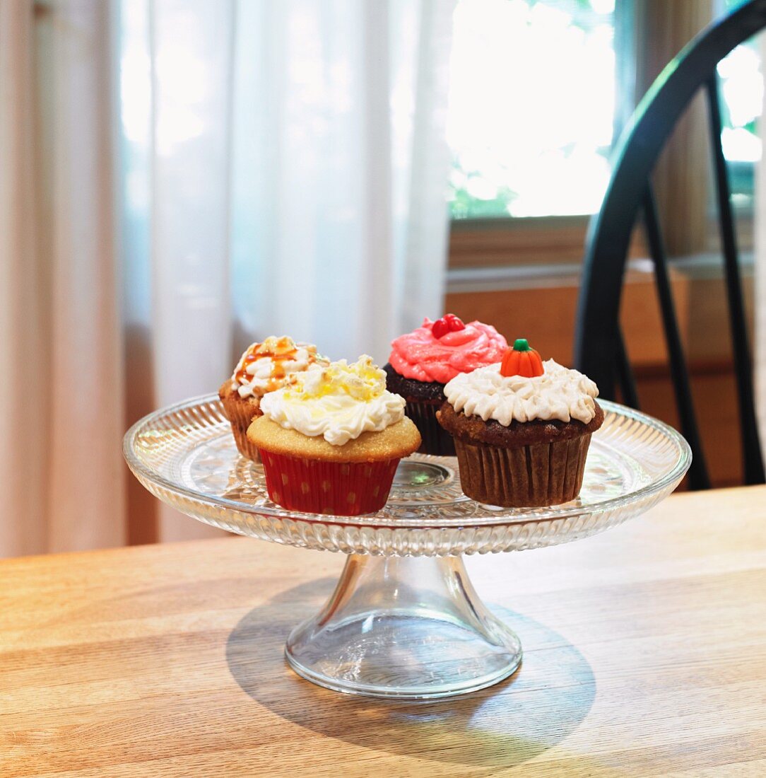 Four Assorted Homemade Cupcakes on a Pedestal Dish