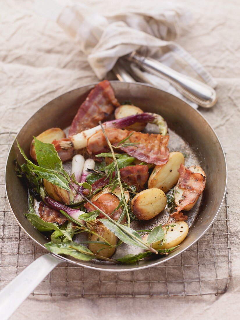 Rustikale Kartoffelpfanne mit Wurzelgemüse, Lauchzwiebeln, Speck und Kräutern